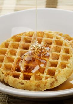 Waffles With  Maple Syrup And Honey In A White Plate