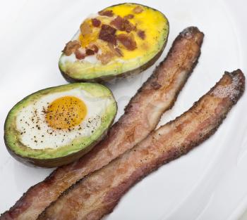 Baked avocado with eggs , cheese and bacon ,close up