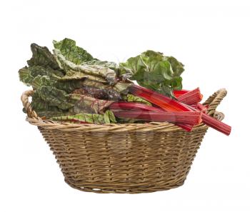 Fresh swiss chard in a basket , isolated on white background