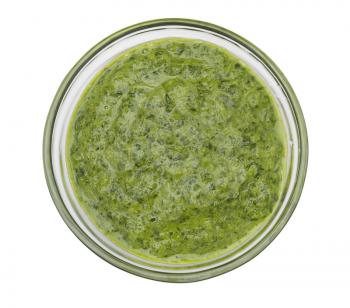 Pesto sauce in a glass bowl isolated on white background
