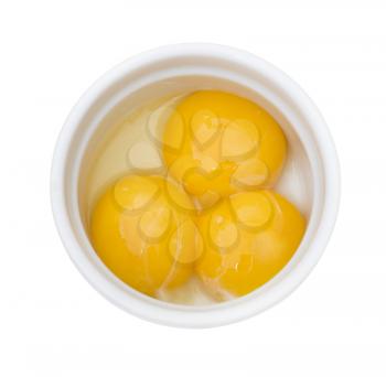 Bright yellow egg yolks in a white bowl isolated on white background