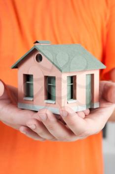 Model of the small house in human hands.