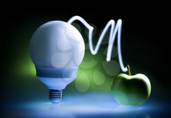 Enercy saving bulb and green apple, concept of green energy