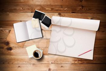 Workspace with coffee cup, instant photos, note paper and notebook on old wooden table 