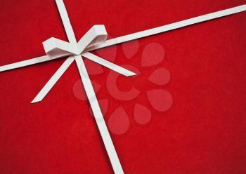 Hand made ribbon and bow on red kraft paper as background. Greeting card