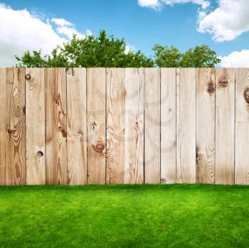 Wooden fence in a green grass 