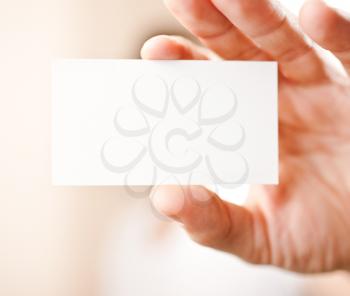 Human hand holding blank business card with copy space, small dof