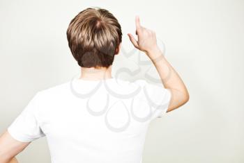Back view of young man pointing up. Idea
