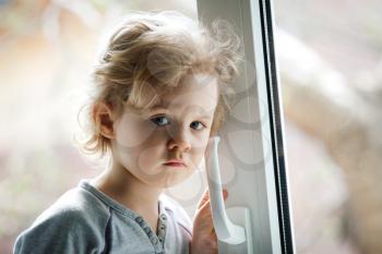 Little girl standing by the window