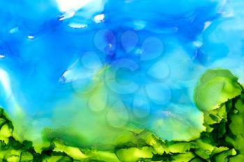 Abstract painted blue with green bottom.Colorful background hand drawn with bright inks and watercolor paints. Color splashes and splatters create uneven artistic modern design.