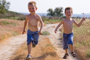 Two young children running together