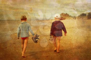 Vintage picture of two young children walking on the beach