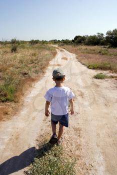 A young child walking on the road
