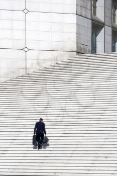 A businessman climbing white stairs - success concept