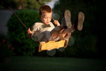A young child playing on a swing