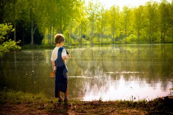 young child standing near a lake