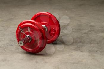 red dumbbells on a cement floor - sport concept
