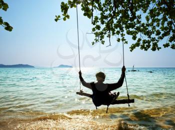 Royalty Free Photo of a Person on a Swing in the Adaman Sea in Thailand
