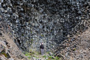 Royalty Free Photo of a Man Standing Near a Rock Wall