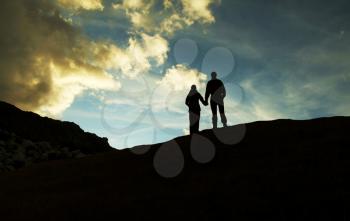Royalty Free Photo of a Girl and Boy Silhouette on a Mountain