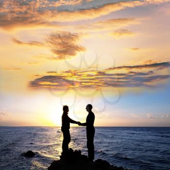 Royalty Free Photo of a Couple Holding Hands on a Beach at Sunrise