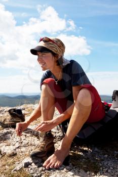 Royalty Free Photo of a Woman Tying Her Shoes While Hiking