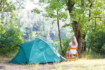 Royalty Free Photo of a Woman Resting Outside a Tent