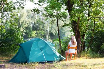 Royalty Free Photo of a Woman Sitting Outside a Tent