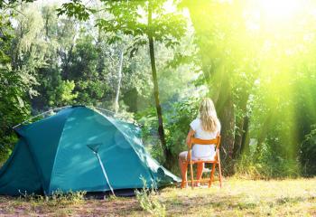 Royalty Free Photo of a Woman Sitting Outside a Tent
