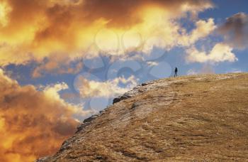 Royalty Free Photo of a Woman Standing on a Mountaintop at Sunset