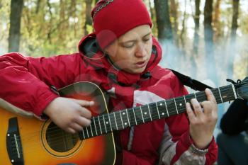 Royalty Free Photo of a Woman Playing Guitar in a Forest