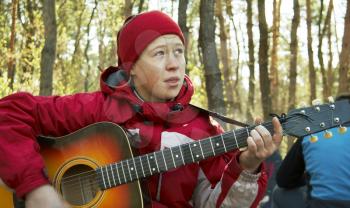 Royalty Free Photo of a Woman Playing Guitar in a Forest