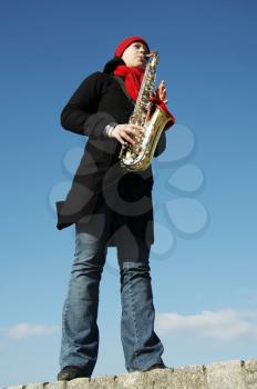 Royalty Free Photo of a Woman Playing Saxophone Outside