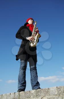Royalty Free Photo of a Woman Playing Saxophone Outside
