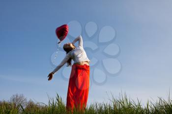 Royalty Free Photo of a Woman in a Field Holding a Balloon