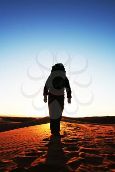 Royalty Free Photo of a Silhouette of a Man Walking in the Desert