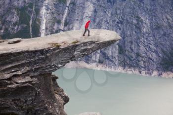 Royalty Free Photo of a Man Standing on a Cliff in the Mountains of Norway
