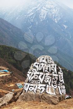 Royalty Free Photo of a Rock with Writing on it at the Himalayan Mountains