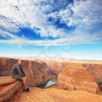 Royalty Free Photo of a Man Sitting at Horseshoe Bend in Utah, USA