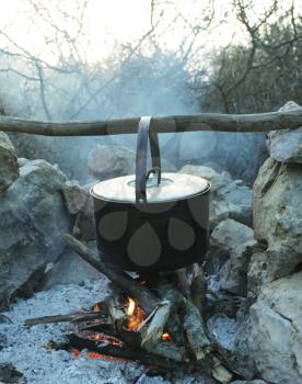 Royalty Free Photo of an Old Kettle Over a Fire