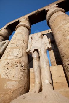 Royalty Free Photo of a Statue and Pillars in Luxor, Egypt