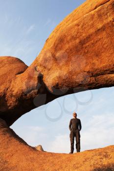 Royalty Free Photo of a Man Standing in a Stone Arch