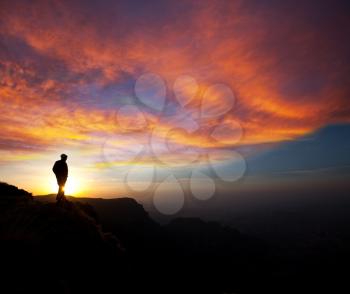 Royalty Free Photo of a Silhouette of a Man on a Cliff