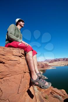 Royalty Free Photo of a Man Sitting on a Cliff