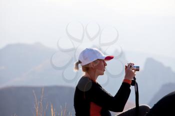 Royalty Free Photo of a Woman Taking a Photograph in the Mountains
