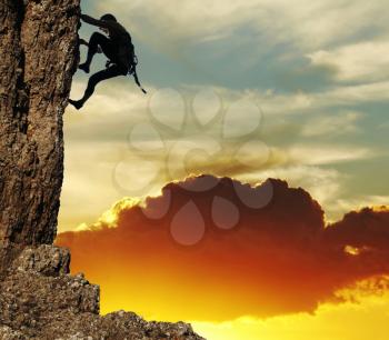 Royalty Free Photo of a Rock Climber at Sunset