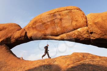 Royalty Free Photo of a Man Running Under a Stone Arch