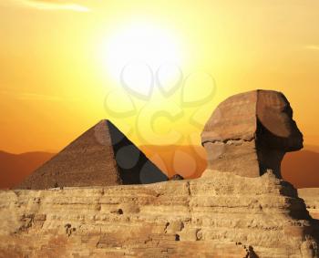 Royalty Free Photo of an Egyptian Sphinx and Pyramid at Sunset