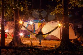 Amazing scene in night camping -girl in hammock on tents background