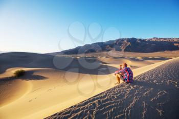 Hiker in sand desert. Sunrise time.